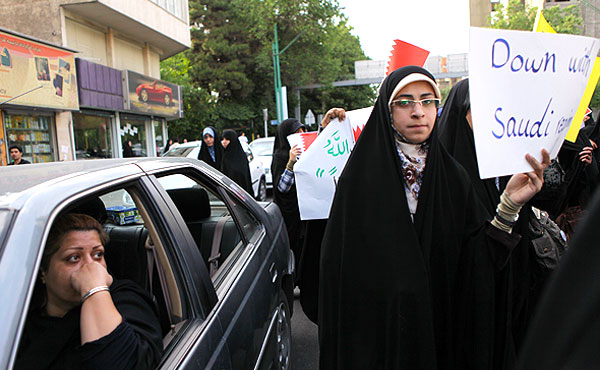 مردم هنگام تماشای راهپیمایی اعتراض‌آمیز دانشجویان مقابل دفتر سازمان ملل متحد در تهران. (مهر)