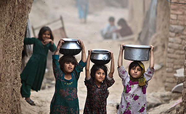 راه رفتن دختران پاکستانی با دیگ‌های آب. (آسوشیتدپرس)